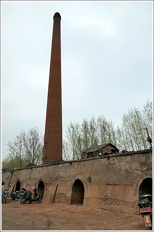 这个砖厂有一大圈砖窑和一个高大的烟囱,规模还真不小呢.