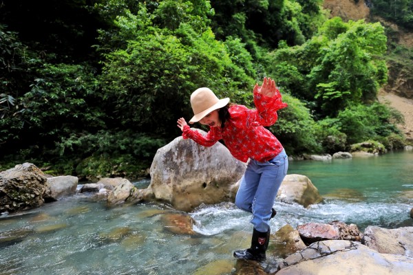 我和阿娥的第一次躲避峡之行来之不易,鹤峰正处在雨季,雨水很多,连续晴3天很难,墨迹天气上的天气预报也不太准,原本跟向导小田约好了10号去的,8号晚上一看天气预报变了,从9号下午开始又有雨,赶紧联系小田改为9号一早进去,还特意交待阿娥要穿红色的衣服。为了少走路,我们决定从新寨村进去。我从燕子出发,阿娥和小田从鹤峰县城出发,8点50我们在入口关卡处会合。照片中左下方的路就是进入躲避峡的土路,水泥路到这里就结束了。 车开到一户人家后院,就要换好装备下车步行了,我自恃穿着凉鞋下水方便,没有换雨靴,后面吃了点小亏